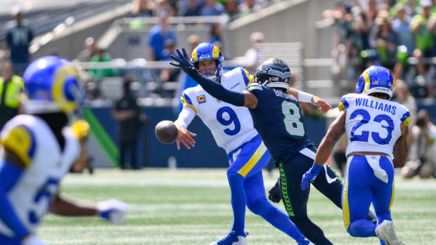 Sep 10, 2023; Seattle, Washington, USA; Los Angeles Rams quarterback Matthew Stafford (9) throws the ball away before being tackled by Seattle Seahawks cornerback Coby Bryant (8) during the first half at Lumen Field. Mandatory Credit: Steven Bisig-USA TODAY Sports