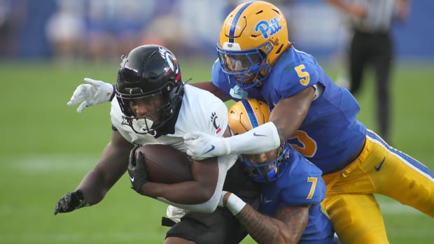 Cincinnati Bearcats Corey Kiner (21) gets tackled by Pittsburgh Panthers Javon McIntyre (7) and Phillip O'Brien Jr. (5) during the first half at Acrisure Stadium in Pittsburgh, PA on September 9, 2023