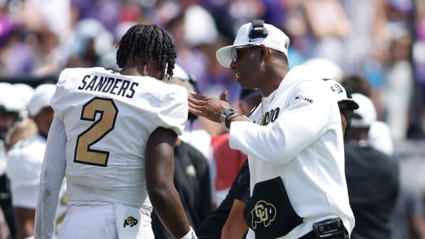 Colorado Buffaloes head coach Deion Sanders talks to quarterback Shedeur Sanders (2) after a touchdown in the fourth quarter against the TCU Horned Frogs at Amon G. Carter Stadium