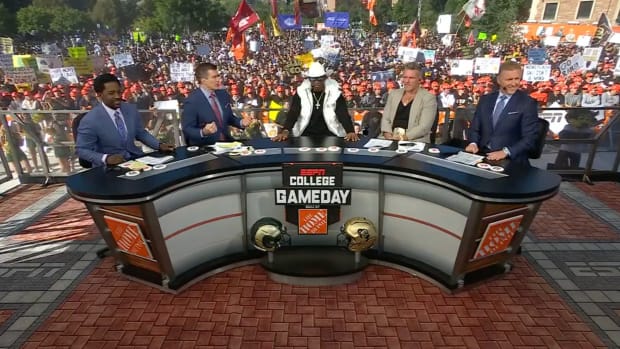 Colorado coach Deion Sanders sits at the “College GameDay” desk with the hosts of the show.