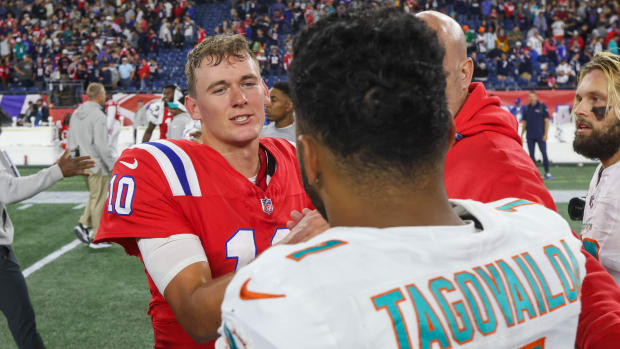 New England Patriots quarterback Mac Jones (10) talks to Miami Dolphins quarterback Tua Tagovailoa (1) after a game at Gillette Stadium.