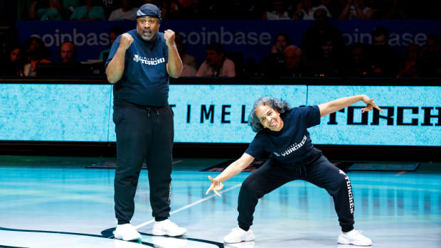 Two dancers from the New York Liberty's Timeless Torches pose on the court during a WNBA game.