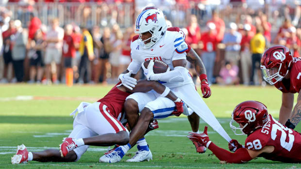 Oklahoma's Danny Stutsman (28) and Gentry Williams (9) tackle SMU's Keldric Luster (6) in the first half of the college football game between the University of Oklahoma Sooners and the Southern Methodist University Mustangs at the Gaylord Family Oklahoma Memorial Stadium in Norman, Okla., Saturday, Sept. 9, 2023.