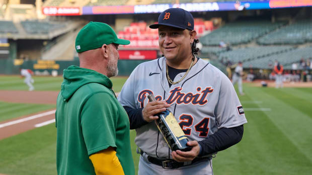Tigers first baseman Miguel Cabrera and Athletics manager Mark Kotsay pose for pictures after the A's gave Cabrera a bottle of win as a farewell gift.