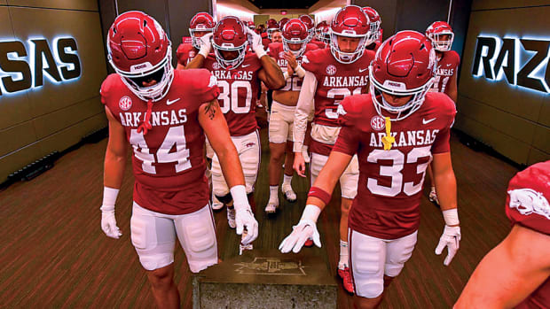 The Arkansas Razorbacks touch a plaque before heading onto the field to play Kent State in Razorback Stadium.