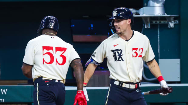 Texas Rangers right fielder Adolis Garcia (53) celebrates with left fielder Evan Carter, right, after scoring in the second inning against the Seattle Mariners at Globe Life Field.
