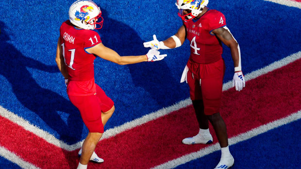 Sep 23, 2023; Lawrence, Kansas, USA; Kansas Jayhawks wide receiver Luke Grimm (11) celebrates with running back Devin Neal (4) after scoring a touchdown during the second half against the Brigham Young Cougars at David Booth Kansas Memorial Stadium. 