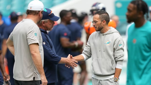 Denver Broncos head coach Sean Peyton, left, and Miami Dolphins head coach Mike McDaniel meet before an NFL game at Hard Rock Stadium in Miami Gardens, Sept. 24, 2023.  