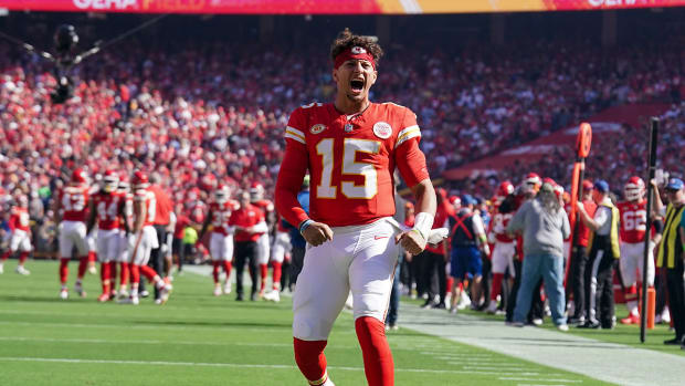 Patrick Mahomes yells to the crowd with his helmet off