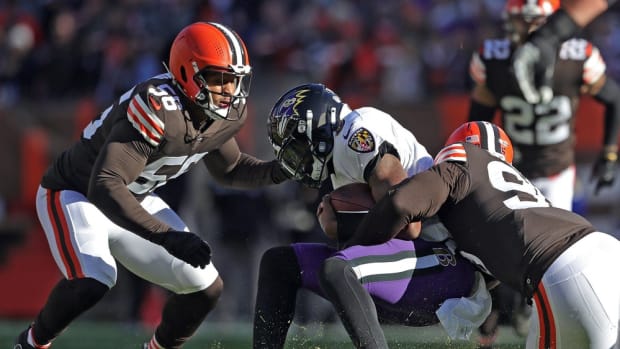 Ravens quarterback Lamar Jackson is brought down by Browns defensive end Myles Garrett (right) during the first half Sunday, Dec. 12, 2021, in Cleveland. Browns 14