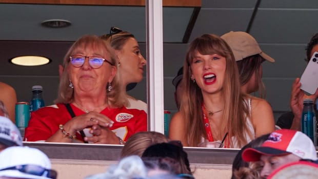 Taylor Swift sits next to Donna Kelce smiling as she watches the Chiefs game from a box