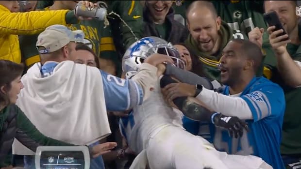 A screenshot of a Packers fan pouring a beer on Lions receiver Amon-Ra St. Brown.
