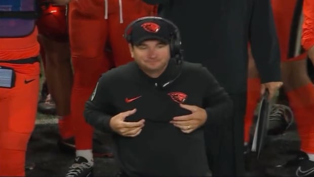 Screenshot of Oregon State football coach Jonathan Smith rubbing his chest during a game against Utah.