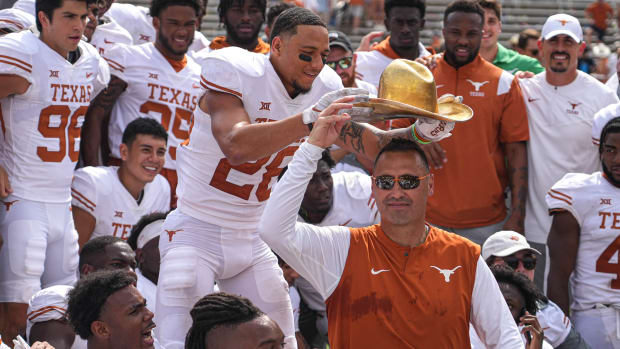 Dallas, Texas, USA: Texas Longhorns Longhorns defensive back Derrin Thompson (28) places the Golden Hat on the head of head coach Steve Sarkisian after a 49-0 victory over the Oklahoma Sooners