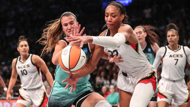 New York Liberty guard Sabrina Ionescu  and Las Vegas Aces forward A'ja Wilson fight for a loose ball.