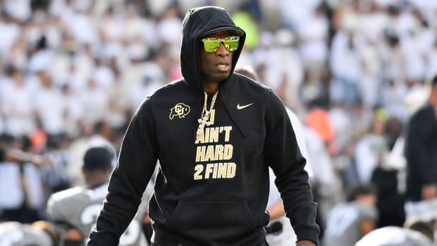 Colorado football coach Deion Sanders looks on while walking on the field during a game.