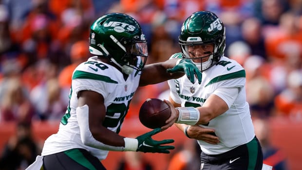 New York Jets quarterback Zach Wilson (2) hands the ball off to running back Breece Hall (20) in the first quarter against the Denver Broncos at Empower Field at Mile High.