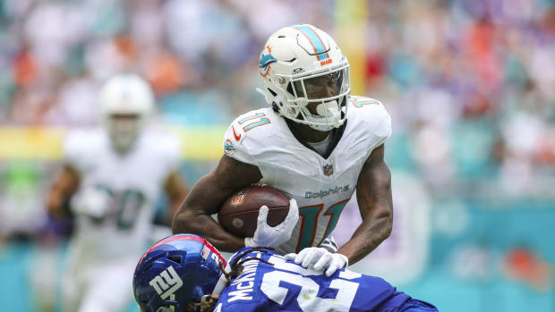 Oct 8, 2023; Miami Gardens, Florida, USA; Miami Dolphins wide receiver Cedrick Wilson Jr. (11) runs with the football as New York Giants safety Xavier McKinney (29) attempts a tackle during the first quarter at Hard Rock Stadium.