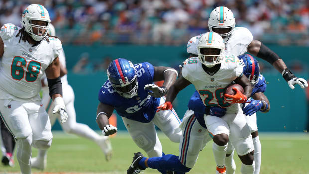 Miami Dolphins running back De'Von Achane (28) breaks free for a gain as New York Giants safety Isaiah Simmons (19) closes in on the play during the first half of an NFL game at Hard Rock Stadium in Miami Gardens, October 8, 2023.