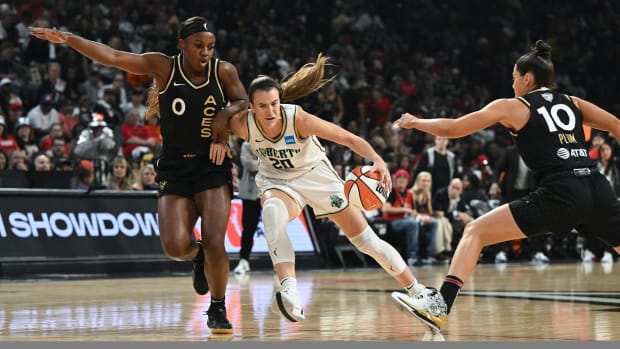 New York Liberty guard Sabrina Ionescu drives past Las Vegas Aces guards Jackie Young and Kelsey Plum in Game 1 of the WNBA Finals.