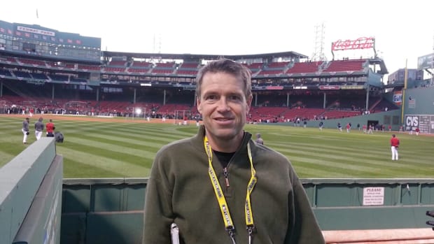 Former baseball writer Jim Caple poses with the inside of Fenway Park in the background.