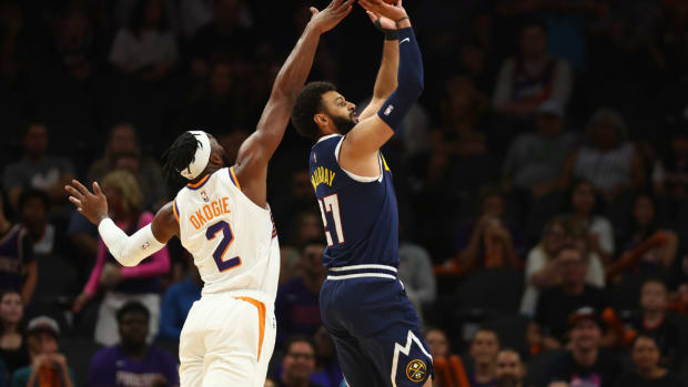 Denver Nuggets guard Jamal Murray (27) shoots the ball under pressure from Phoenix Suns forward Josh Okogie (2) during a preseason game at Footprint Center.