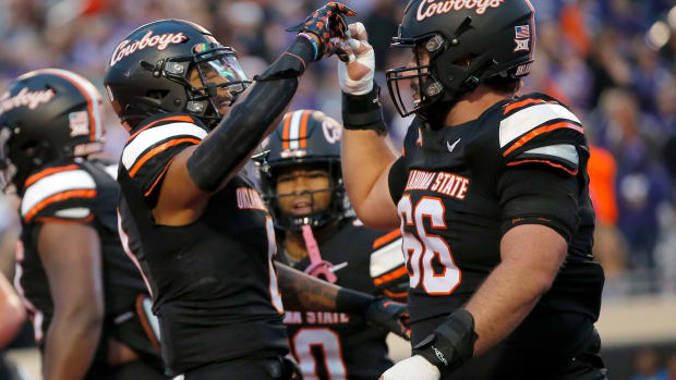 Oklahoma State's Ollie Gordon II (0)celebrates his touchdown with Oklahoma State's Joe Michalski (66) in the first half of the college football game between the Oklahoma State University Cowboys and the Kansas State Wildcats at Boone Pickens Stadium in Stillwater. Okla., Friday, Oct. 6, 2023.