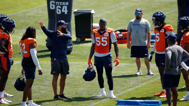 The Broncos linebackers stand around pass rusher Frank Clark during a training camp practice.