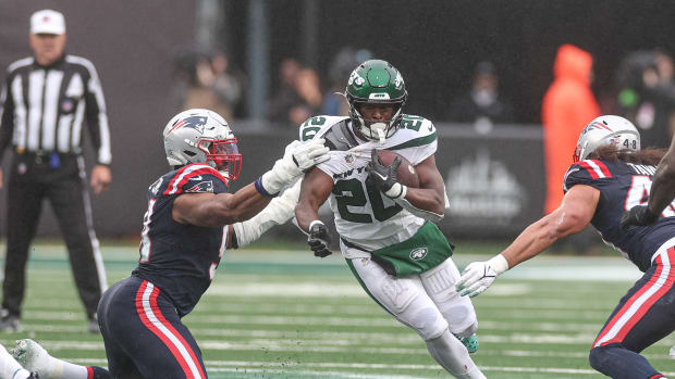 Jets' RB Breece Hall (20) runs through a tackle attempt by the Patriots