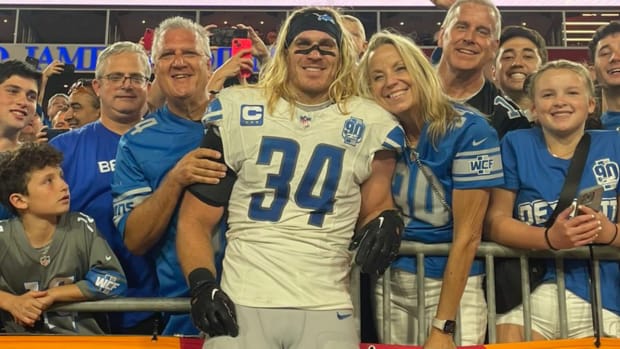 Detroit Lions linebacker Alex Anzalone poses with his parents and fans after a 20–6 victory over Tampa Bay on Oct. 15, 2023.
