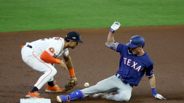 Texas Rangers outfielder Evan Carter, right, slides in with a double in front of Houston Astros shortstop Jeremy Pena during the first inning of Game 1 of the ALCS at Minute Maid Park on Oct. 15.