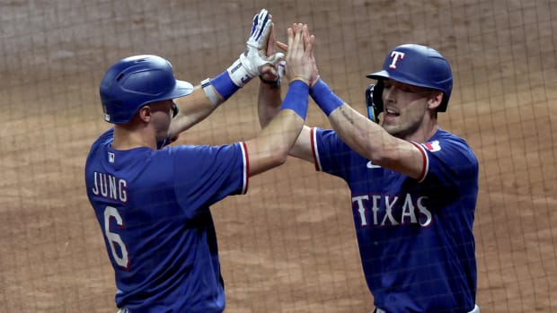 Rangers’ Evan Carter and Josh Jung high five after Carter scores a run vs. Astros in ALCS Game 1.