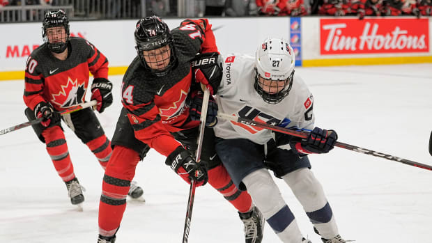 Nov 21, 2021; Kingston, Ontario, CAN; Canada defence Renata Fast (14) USA forward Britta Curl (27) battle for position during the third period of a Rivalry Series women's hockey game at Leon's Centre. Mandatory Credit: John E. Sokolowski-USA TODAY Sports