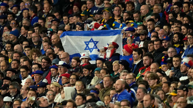 An Israel flag is held up in a crowd
