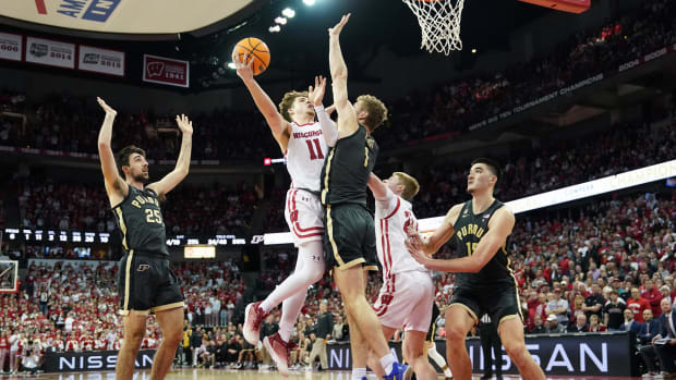 Mar 2, 2023; Madison, Wisconsin, USA; Wisconsin Badgers guard Max Klesmit (11) shoots the ball under coverage by Purdue Boilermakers forward Caleb Furst (1) and guard Ethan Morton (25) during the second half at the Kohl Center. Mandatory Credit: Kayla Wolf-USA TODAY Sports
