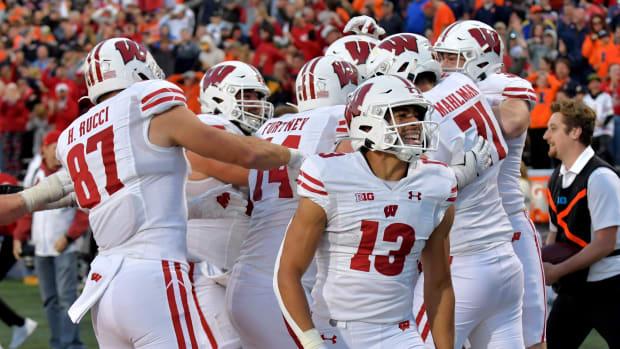 Oct 21, 2023; Champaign, Illinois, USA; Wisconsin Badgers players celebrate a touchdown during the second half against the Illinois Fighting Illini at Memorial Stadium. Mandatory Credit: Ron Johnson-USA TODAY Sports