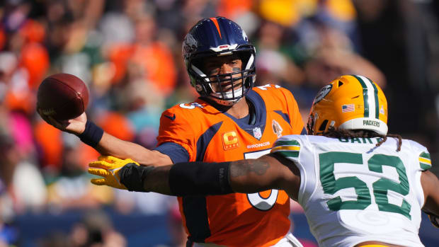 Denver Broncos quarterback Russell Wilson (3) passes under pressure from Green Bay Packers linebacker Rashan Gary (52) in the first quarter at Empower Field at Mile High.