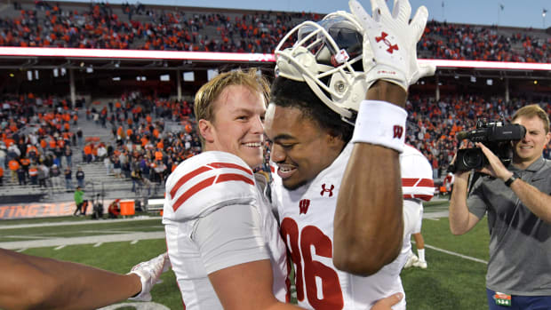 Oct 21, 2023; Champaign, Illinois, USA; Wisconsin Badgers quarterback Braedyn Locke (18) celebrates a 25-21 win over the Illinois Fighting Illini during the second half at Memorial Stadium. Mandatory Credit: Ron Johnson-USA TODAY Sports