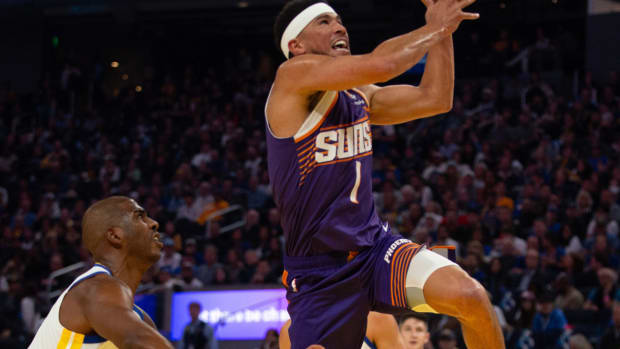 Phoenix Suns guard Devin Booker (1) drives past Golden State Warriors guard Chris Paul (3) during the first quarter at Chase Center.