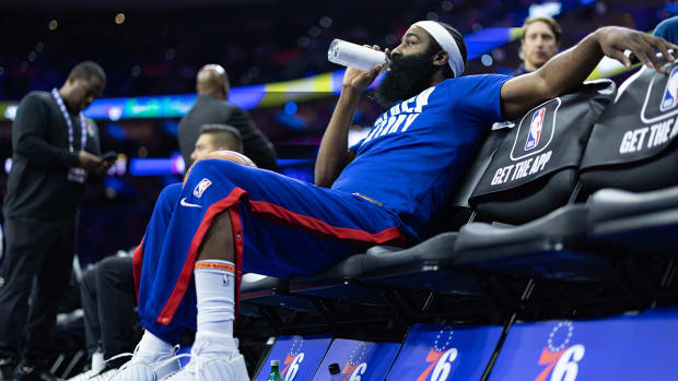 James Harden sits on the 76ers bench.