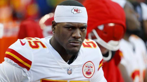 Chiefs pass rusher Frank Clark looks on without a helmet during a game.