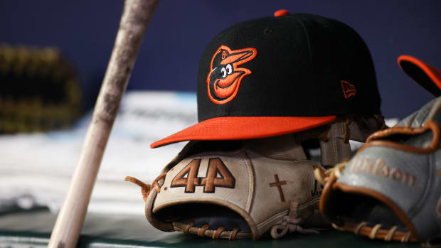 May 5, 2023; Atlanta, Georgia, USA; A detailed view of a Baltimore Orioles hat and glove in the dugout during a game against the Atlanta Braves in the seventh inning at Truist Park. Mandatory Credit: Brett Davis-USA TODAY Sports