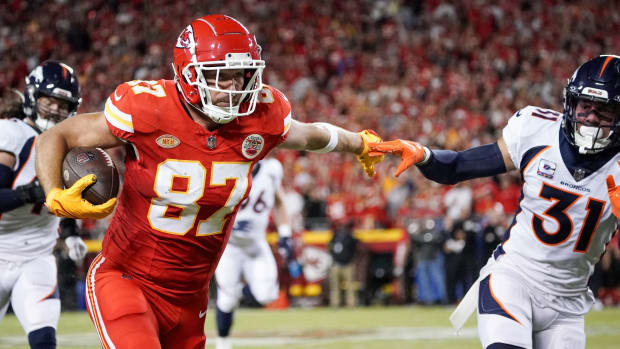 Kansas City Chiefs tight end Travis Kelce (87) runs the ball as Denver Broncos safety Justin Simmons (31) defends during the game at GEHA Field at Arrowhead Stadium.