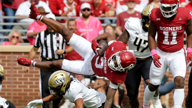 Oklahoma's Jalil Farooq (3) is brought down in the Demari Henderson (8) in the first half of the college football game between the University of Oklahoma Sooners and the University of Central Florida Knights at Gaylord Family Oklahoma-Memorial Stadium in Norman, Okla., Saturday, Oct., 21, 2023.  