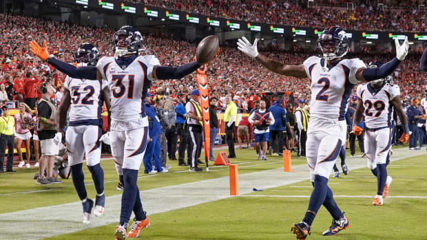 Denver Broncos safety Justin Simmons (31) and cornerback Pat Surtain II (2) and cornerback Damarri Mathis (27) celebrate after Simmon s interception against the Kansas City Chiefs during the first half at GEHA Field at Arrowhead Stadium.