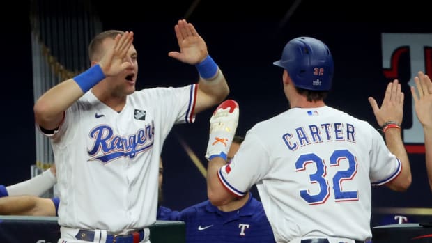 Texas Rangers center fielder Evan Carter, right, and third baseman Josh Jung celebrate during the World Series in October. Both standout rookies will sign autographs at the Dallas Card Show in Allen. Jung will sign from 2 to 4 p.m. on Jan. 20, and Carter will sign from noon to 2 p.m. on Jan. 21.