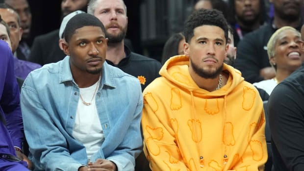 Suns teammates Bradley Beal and Devin Booker sit on the bench.