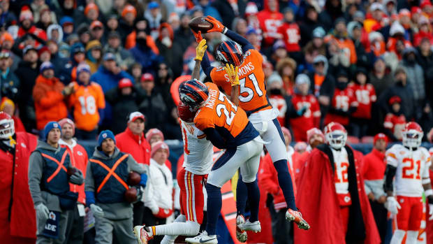 Denver Broncos safety Justin Simmons (31) intercepts a pass intended for Kansas City Chiefs wide receiver Marquez Valdes-Scantling (11) as cornerback Damarri Mathis (27) defends in the fourth quarter at Empower Field at Mile High.