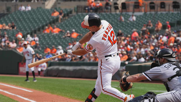 Aug 30, 2023; Baltimore, Maryland, USA; Baltimore Orioles outfielder Adam Frazier (12) connects on a run scoring base hit in the first inning against the Chicago White Sox at Oriole Park at Camden Yards. Mandatory Credit: Mitch Stringer-USA TODAY Sports