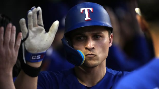 Corey Seager sports a stoic face as he is congratulated by teammates in the dugout after hitting a home run in Game 3 of the 2023 World Series.